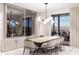 Elegant dining room with a wine wall, modern light fixture, and access to the patio at 14521 E Corrine Dr, Scottsdale, AZ 85259