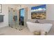 Modern primary bathroom featuring a glass shower, soaking tub, and desert views at 1711 W Caramel Ct, Queen Creek, AZ 85144