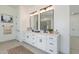 Modern double vanity bathroom with white cabinets, black fixtures, and large mirrors at 1805 W Caramel Ct, Queen Creek, AZ 85144