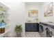 Spacious laundry room with ample shelving, washer and dryer, and unique floor tiles at 1805 W Caramel Ct, Queen Creek, AZ 85144