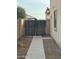 Gated side yard with a concrete path and security camera at 300 S 151St Ave, Goodyear, AZ 85338