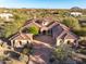 Stunning aerial view of a tile-roofed home with a circular driveway and desert landscaping at 36701 N Porta Nuova Rd, Scottsdale, AZ 85262
