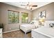 Bedroom with two white twin beds, ceiling fan, and windows with wood blinds at 36701 N Porta Nuova Rd, Scottsdale, AZ 85262