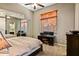 Bedroom with mirrored closet doors, ceiling fan, desk, and window with wood blinds at 36701 N Porta Nuova Rd, Scottsdale, AZ 85262