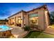 Backyard at dusk with pool, spa, putting green, covered patio, and outdoor lighting at 36701 N Porta Nuova Rd, Scottsdale, AZ 85262