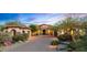Inviting home exterior at dusk with paver driveway, stone accents, and desert landscaping at 36701 N Porta Nuova Rd, Scottsdale, AZ 85262