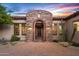 Close-up of the arched stone entryway with front door and desert landscaping at 36701 N Porta Nuova Rd, Scottsdale, AZ 85262