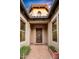 Front entry with a dark wood door, potted plants, and paver walkway at 36701 N Porta Nuova Rd, Scottsdale, AZ 85262
