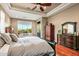 Large main bedroom with sitting area, ceiling fan, and backyard views at 36701 N Porta Nuova Rd, Scottsdale, AZ 85262