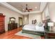 Main bedroom featuring hardwood floors, a ceiling fan, and elegant wooden furniture at 36701 N Porta Nuova Rd, Scottsdale, AZ 85262