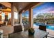 Spacious covered patio with dining area and views of the pool and waterfall at 36701 N Porta Nuova Rd, Scottsdale, AZ 85262
