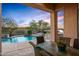 Covered patio with dining table, overlooking the pool and desert landscape at 36701 N Porta Nuova Rd, Scottsdale, AZ 85262
