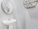 Small half bathroom with pedestal sink and floating shelves at 36909 N Coronado Ln, San Tan Valley, AZ 85140