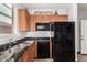 Modern kitchen with granite countertops and black appliances at 36909 N Coronado Ln, San Tan Valley, AZ 85140