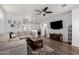 Spacious living room with L-shaped sofa, wood floors, and a large TV at 36909 N Coronado Ln, San Tan Valley, AZ 85140
