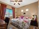 Bedroom with floral bedding, ceiling fan, and windows with curtains at 6202 E Mckellips Rd # 66, Mesa, AZ 85215
