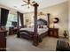 Main bedroom featuring a four-poster bed, carpeted flooring, and a TV at 6202 E Mckellips Rd # 66, Mesa, AZ 85215