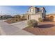 A two-story house with beige siding, and stone accents, a two-car garage, and low-maintenance landscaping at 7120 W Maya Way, Peoria, AZ 85383