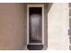 The black front door of the home, accented by the textured stucco walls at 7120 W Maya Way, Peoria, AZ 85383