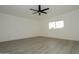 Empty bedroom with gray wood-look flooring, white walls, a ceiling fan, and a window at 11805 N 31St Ave, Phoenix, AZ 85029