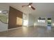 Living room with gray wood floors, a large circular mirror, wood slat wall, and ceiling fan at 11805 N 31St Ave, Phoenix, AZ 85029