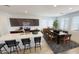 Modern kitchen with island, dark wood cabinets, stainless steel appliances, and dining area at 12639 W Parkway Ln, Avondale, AZ 85323