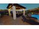 Relaxing patio area with outdoor kitchen, bar seating, and lounge chairs by the pool at 14959 S 184Th Ave, Goodyear, AZ 85338