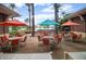 Outdoor patio area with colorful umbrellas and seating, overlooking the pool and fountains at 14959 S 184Th Ave, Goodyear, AZ 85338