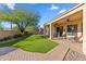 Landscaped backyard with a covered patio, pavers, and artificial grass at 1613 W Ainsworth Dr, Anthem, AZ 85086