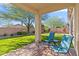 Covered patio with seating, lush artificial turf lawn and desert landscaping at 1613 W Ainsworth Dr, Anthem, AZ 85086