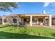 Exterior view of the home's back with covered patio, green lawn at 1613 W Ainsworth Dr, Anthem, AZ 85086