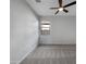 Empty bedroom with patterned gray carpet, white walls, and a ceiling fan at 19724 N Lief Rd, Maricopa, AZ 85138