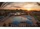 Inviting community pool with lounge chairs, umbrellas, and a separate area at sunset at 20224 W Roma Ave, Litchfield Park, AZ 85340