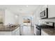 Bright kitchen with granite countertops, stainless steel appliances, and a view of the backyard at 38085 W Excussare Way, Maricopa, AZ 85138