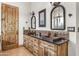 Spacious bathroom with double copper sinks, decorative tile backsplash, wood cabinets, and rustic accents at 4450 Black Mountain Rd, Wickenburg, AZ 85390