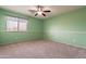 Bright green bedroom with ceiling fan, window, and carpeted floors at 8614 W Purdue Ave, Peoria, AZ 85345