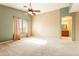 Main bedroom featuring vaulted ceiling, ceiling fan, window with curtains, and ensuite bathroom entrance at 8614 W Purdue Ave, Peoria, AZ 85345