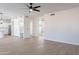 Spacious living room with wood-look flooring, ceiling fan, and neutral walls at 9902 E Meseto Ave, Mesa, AZ 85209