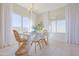 Bright dining area with white table, wicker chairs, and large windows at 1365 E Avenida Ellena Ln, Casa Grande, AZ 85122