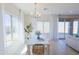 Dining area with white table, wicker chairs, large window, and sliding glass door at 1365 E Avenida Ellena Ln, Casa Grande, AZ 85122