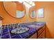 Bathroom with double sinks, decorative tile countertop, and orange walls at 1714 E Behrend Dr, Phoenix, AZ 85024