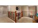 Upper hallway with wood railing, neutral walls and carpet at 19409 W Pasadena Ave, Litchfield Park, AZ 85340