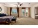 Large main bedroom featuring ceiling fan, balcony access, and ensuite bathroom at 19409 W Pasadena Ave, Litchfield Park, AZ 85340