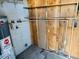 Laundry room with built-in shelving, water heater, and exposed plumbing at 2341 E Betty Elyse Ln, Phoenix, AZ 85022