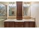 Bathroom with double vanity, wood cabinets, and large mirrors at 29613 N 46Th St, Cave Creek, AZ 85331