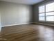 Empty bedroom with wood-look flooring, neutral gray walls, and shuttered windows at 3526 W Dunlap Ave # 159, Phoenix, AZ 85051