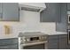 Close-up view of the kitchen's stainless steel appliances, white tile backsplash, and gray cabinetry at 42140 N Golden Trl, San Tan Valley, AZ 85140