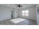 Bright bedroom with wood-look tile, ceiling fan, window, and ensuite bathroom access at 43521 W Carefree Pl, Maricopa, AZ 85138