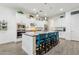 Modern kitchen with white cabinets, stainless steel appliances, and a large island with blue bar stools at 4655 N 183Rd Dr, Goodyear, AZ 85395