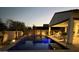 Backyard at twilight featuring a pool, covered patio, and beautiful landscape lighting at 4655 N 183Rd Dr, Goodyear, AZ 85395